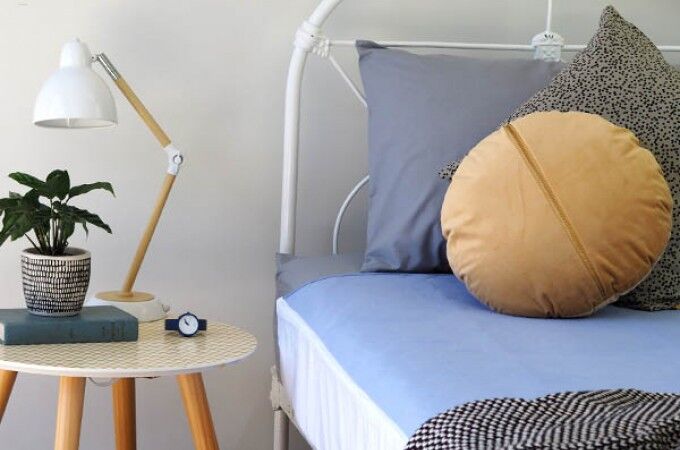 Close up image of bed and side table with Conni Bed Pad exposed